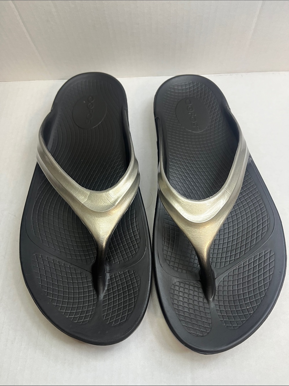 OOFOS Women's Black Flip Flop Sandals with Metallic Silver Straps